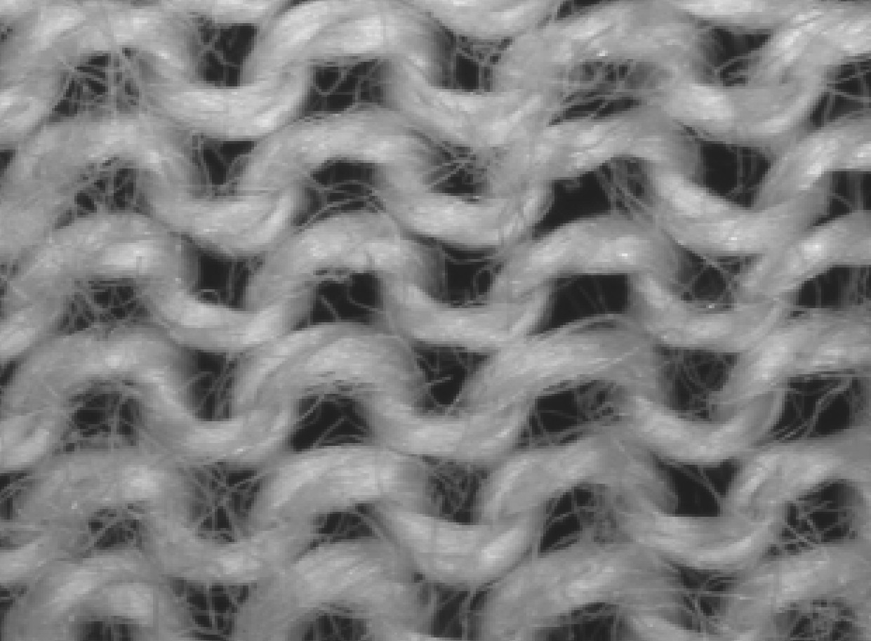 A close-up of the technical back of the same knit, where the yarn reads as horizontal rows of semicircular loop heads instead of vertical V shapes.
