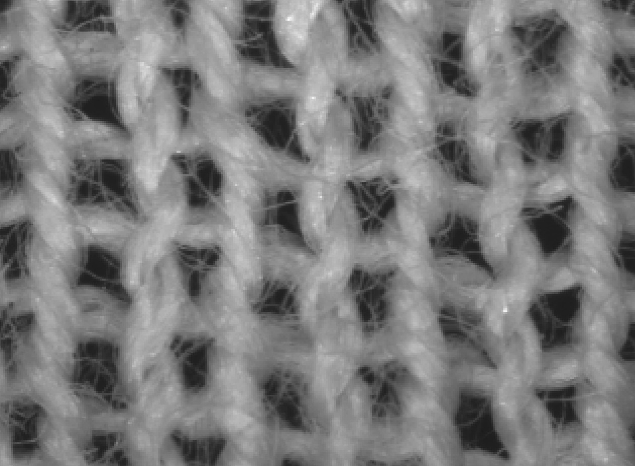 A close-up of the technical face of a plain weft knit, where the yarn reads as vertical columns of V shapes, one column for each needle.